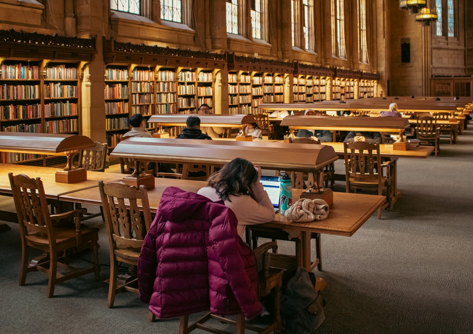 Students reading at wooden desks in the University of Washington’s Suzzallo Library